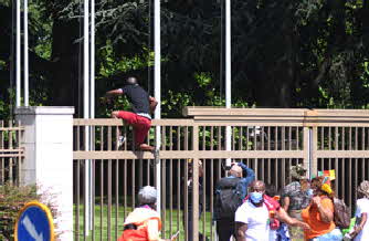 Cameroon prtester climbing UN gate